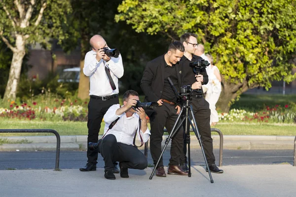 Een groep van bruiloft fotografen in de straten van Boedapest houdt een fotosessie voor een paar jonggehuwden. — Stockfoto