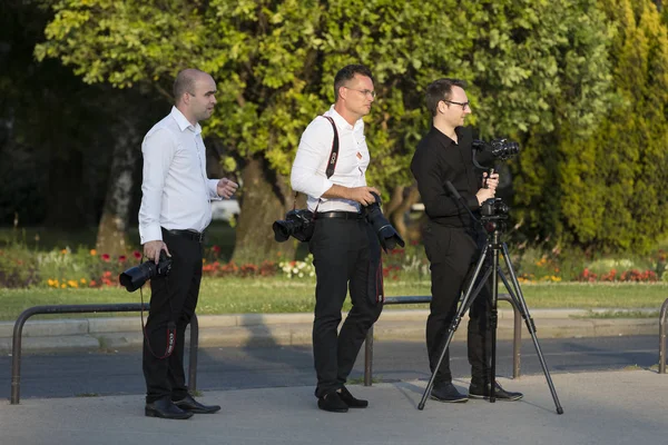 Un groupe de photographes de mariage dans les rues de Budapest organise une séance photo pour quelques jeunes mariés . — Photo