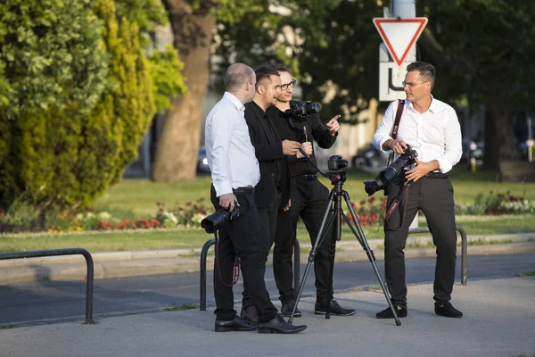 Un groupe de photographes de mariage dans les rues de Budapest organise une séance photo pour quelques jeunes mariés . — Photo