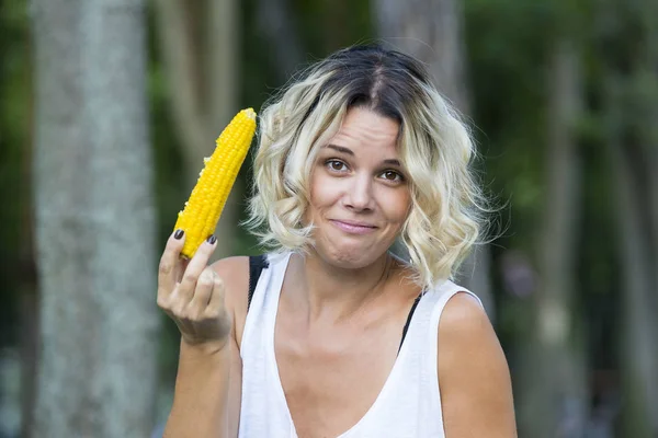 La chica está comiendo maíz dulce hervido — Foto de Stock