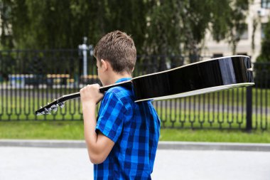 Bir gitar ile genç üzgün adam 