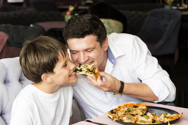 Syn ojca jedzenie włoska pizza — Zdjęcie stockowe