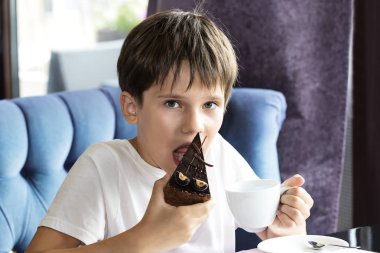 Oğlan büyük bir dilim pasta yiyor