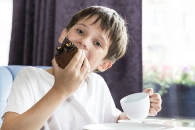 Oğlan büyük bir dilim pasta yiyor
