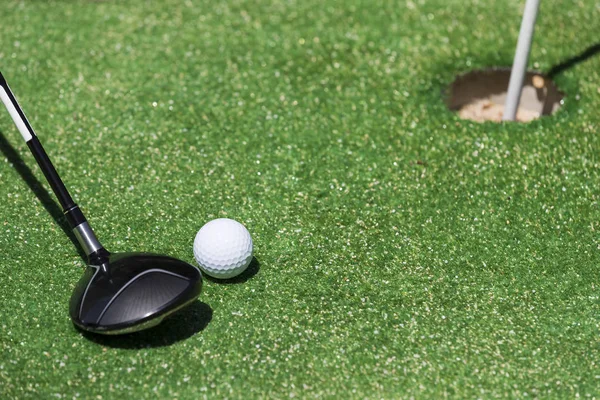 Stick mit einem Ball auf einem künstlichen Golf — Stockfoto