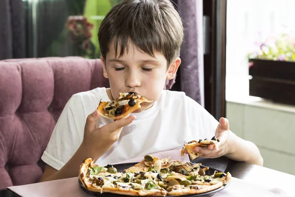 Мальчик ест пиццу. — стоковое фото
