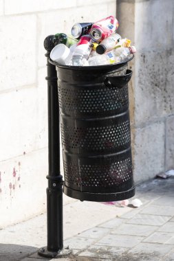 Sokak çöp kutularını tarar üst kadar plastik şişe ile çöp kutuları ile dolu.