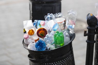 Sokak çöp kutularını tarar üst kadar plastik şişe ile çöp kutuları ile dolu.