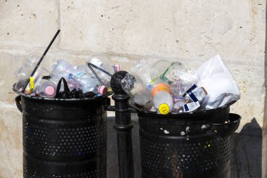 Sokak çöp kutularını tarar üst kadar plastik şişe ile çöp kutuları ile dolu.