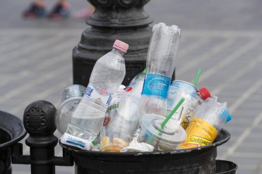 Sokak çöp kutularını tarar üst kadar plastik şişe ile çöp kutuları ile dolu.