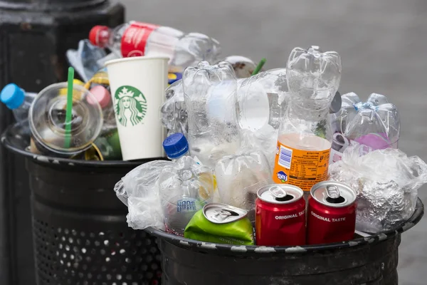 Sokak çöp kutularını tarar üst kadar plastik şişe ile çöp kutuları ile dolu.