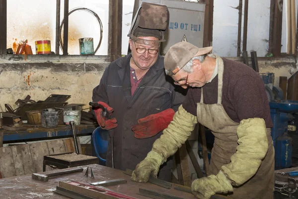 Metalworking shop workers work behind machines and apparatuses to create steel structures.Kharkov — Stock Photo, Image