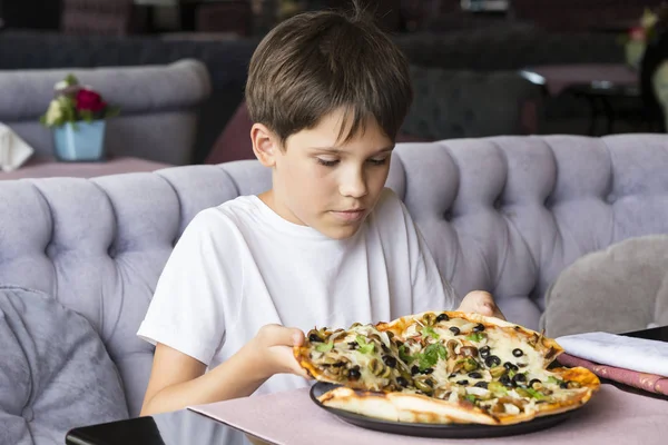 Мальчик ест пиццу. — стоковое фото