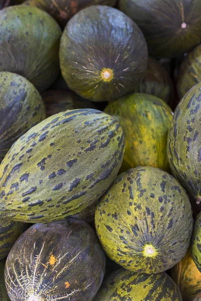 Background of ripe melons close-up on the market
