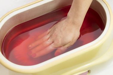 Güzellik salonunda kadın ellerine parafin tedavisi uygula 