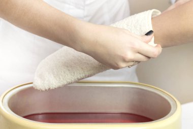 Güzellik salonunda kadın ellerine parafin tedavisi uygula