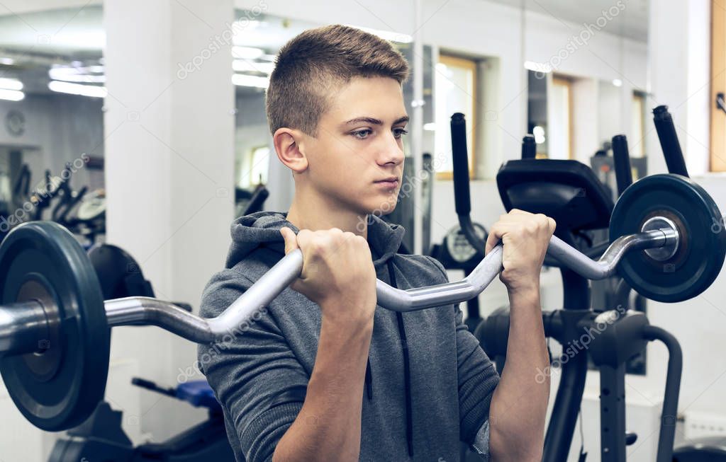 The teenager is engaged in power fitness in the gym.