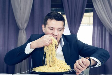 Man makarna büyük bir bölümünü bir restoranda yemek 