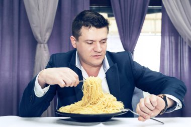 Man makarna büyük bir bölümünü bir restoranda yemek 