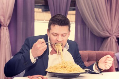 Man makarna büyük bir bölümünü bir restoranda yemek 