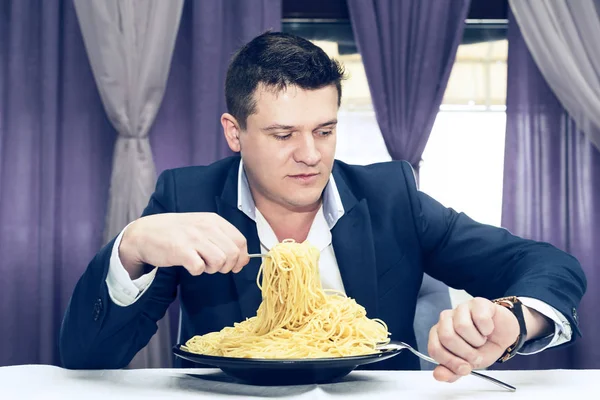 Man makarna büyük bir bölümünü bir restoranda yemek 