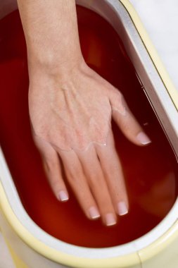 Güzellik salonunda kadın ellerine parafin tedavisi uygula