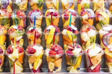 Plastik bir kap içinde taze meyve salatası dilimlenmiş