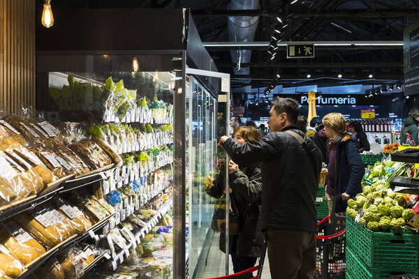 БАРСЕЛОНА, Испания - 11 ЯНВАРЯ 2018: Посетители и продукты на полках и холодильнике продуктового супермаркета Carrefour
