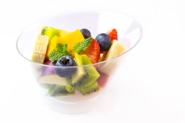 Muz, çilek, çilek, beyaz bir arka plan üzerinde plastik kaplar içinde meyve salatası.