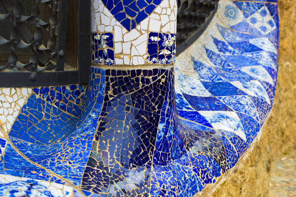 BARCELONA, SPAIN - 13 JANUARY 2018: Elements of mosaic fragments Gaudi's mosaic work in Park Guell In winter in the city of Barcelona.