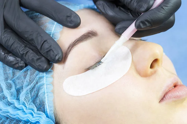Woman on the procedure for eyelash extensions, eyelashes lamination.