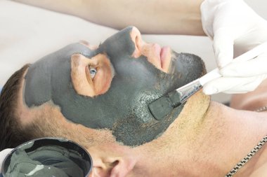 Bir adam yüzünü Güzellik Salonu bir kil maskesi ile temizlik işlemi yapar