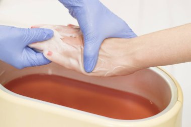 Güzellik salonunda kadın ellerine parafin tedavisi uygula 