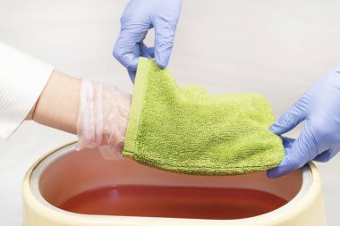 Güzellik salonunda kadın ellerine parafin tedavisi uygula 