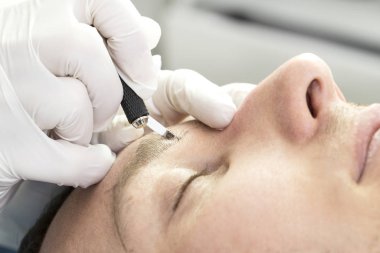Erkeklerin güzellik salonundaki kaşlarını iyileştirmek için yapılan mikro patinaj işlemi..