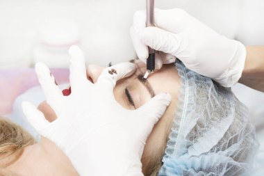 Kadınlar için bir güzellik salonunda mikropatenli kaş dövme prosedürü.