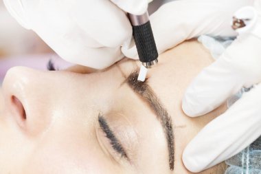 Kadınlar için bir güzellik salonunda mikropatenli kaş dövme prosedürü.