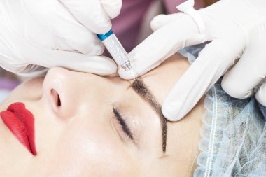 Kadınlar için bir güzellik salonunda mikropatenli kaş dövme prosedürü.