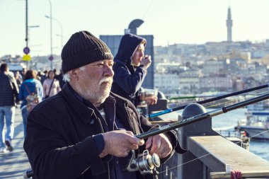 Istanbul, Türkiye - 1 Nisan, 2017: balıkçılar Galata Köprüsü'nde balık Haliç Bay Türkiye'de