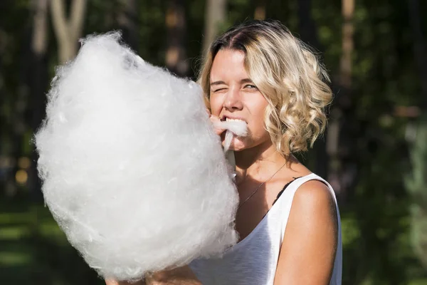 夏の公園で甘い綿菓子を食べる女子高生 — ストック写真