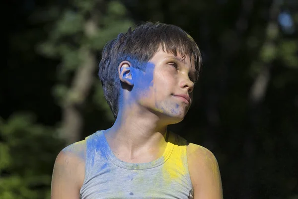 ホリデー ホリのお祝いで青と黄色の塗料で少年の肖像画 — ストック写真