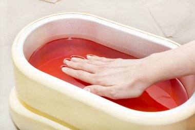 Kadın elinin parafin terapisi bir güzellik salonunda çekilir..
