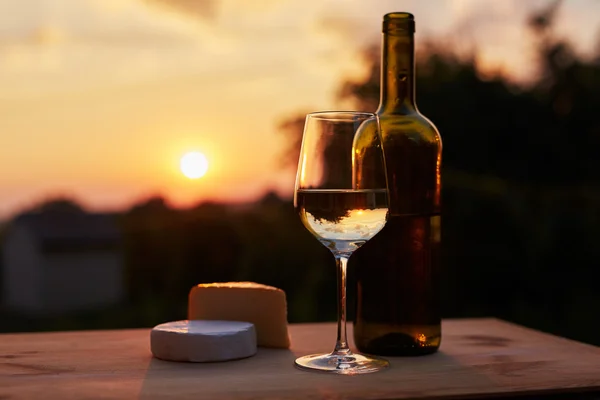 Зображення з низьким ключем, келих білого вина з пляшкою — стокове фото