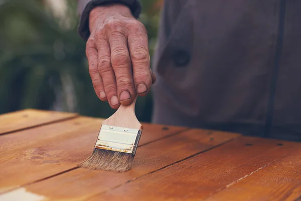 Close up of a hand painting a wooden table — Stock Photo, Image