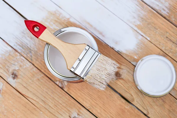 Paintbrush with can on wooden table — Stock Photo, Image