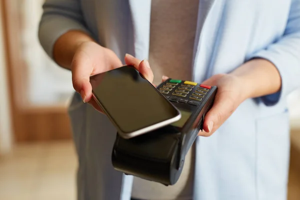 Женщина, платящая с помощью технологии NFC — стоковое фото
