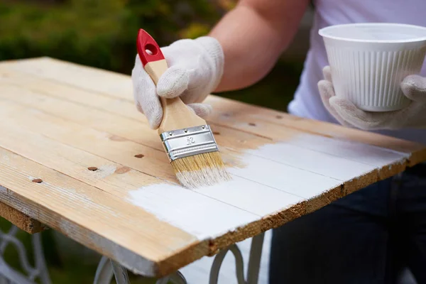 Man painting on a wooden table — Stock Photo, Image