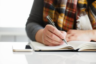 Kadın eli içinde siyah günlük yazıyor