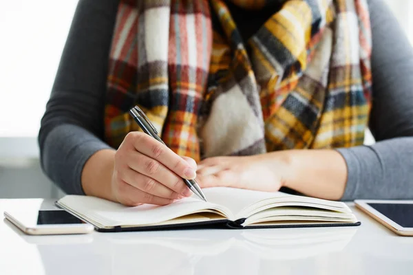 Vrouw schrijft naar zwarte dagboek — Stockfoto