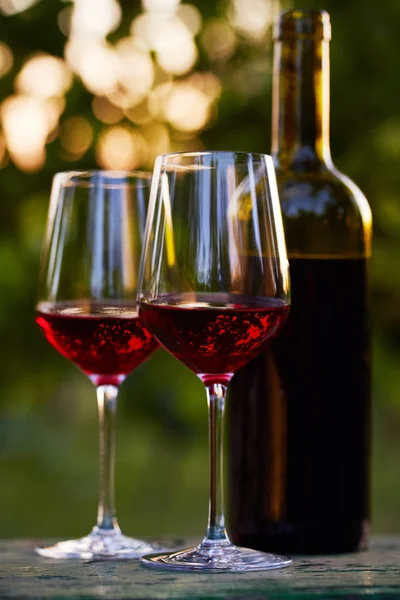 Дві склянки червоного вина і пляшки — стокове фото
